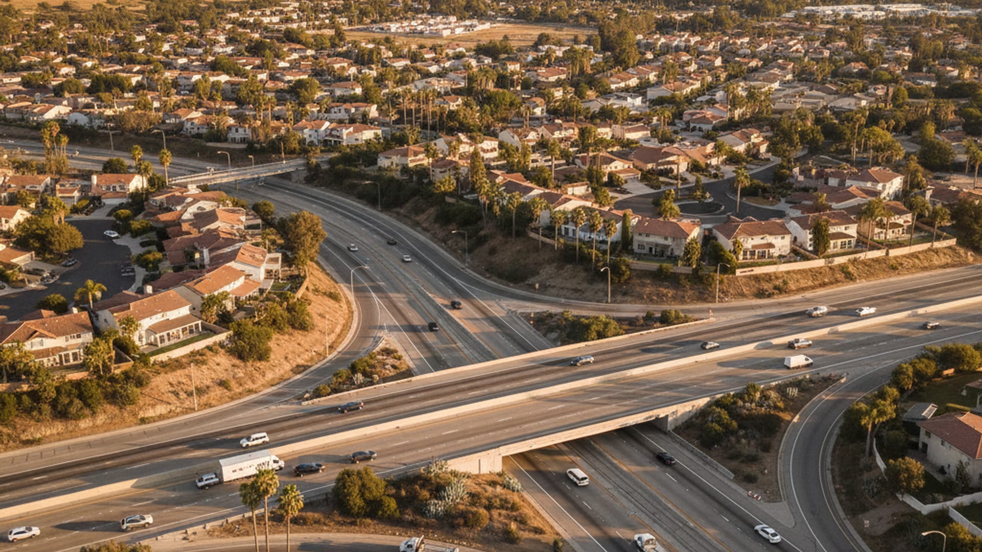 Elevated drone view of the Memphis highway network with the Mississippi River, downtown, and neighborhoods at golden hour